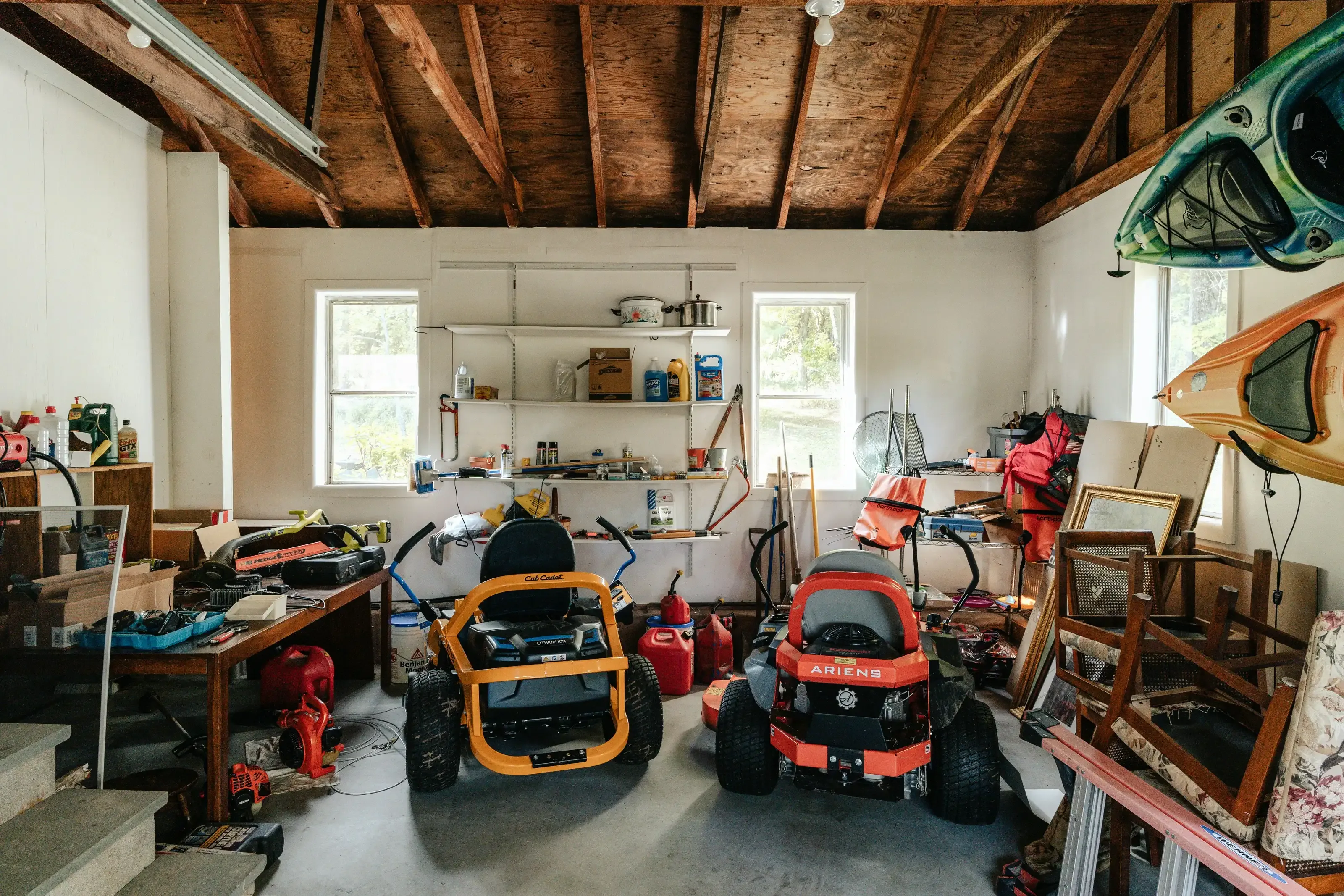 Garage rempli de divers équipements, outils et objets entreposés, illustrant l'accumulation de biens au fil des années